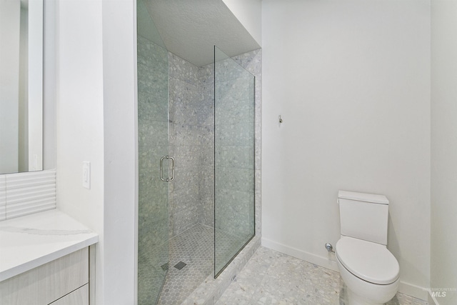 bathroom with a stall shower, toilet, vanity, and baseboards