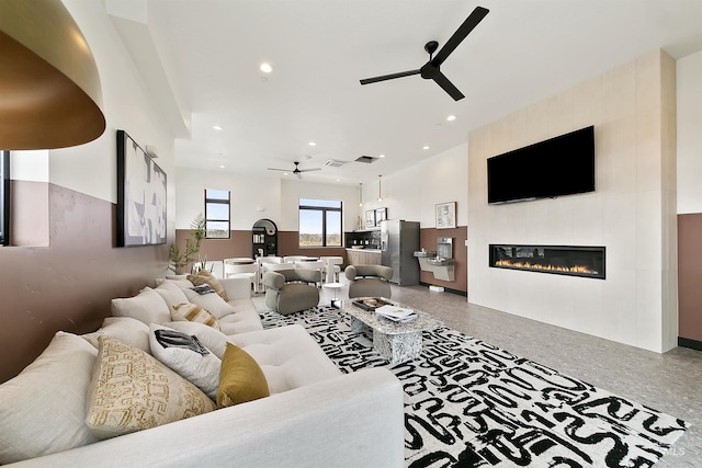 living area with recessed lighting, ceiling fan, and a fireplace