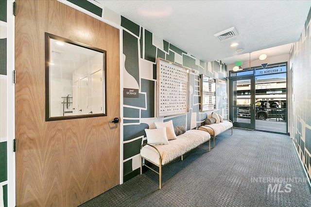 interior space with visible vents, carpet floors, and a textured ceiling