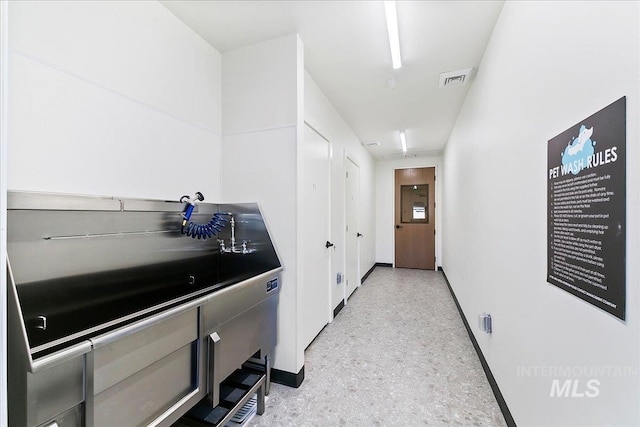 interior space featuring light speckled floor and baseboards