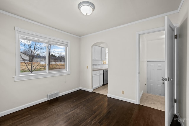 unfurnished bedroom featuring dark hardwood / wood-style flooring, ensuite bath, and crown molding