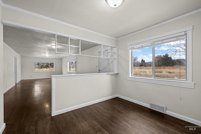 empty room featuring dark hardwood / wood-style floors and ornamental molding