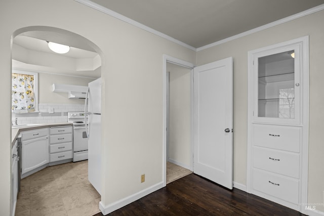 interior space featuring white cabinetry, white range with electric stovetop, backsplash, crown molding, and hardwood / wood-style flooring