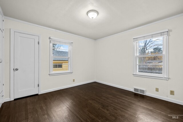 unfurnished room with crown molding, plenty of natural light, and dark wood-type flooring