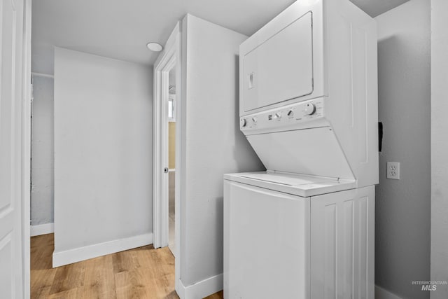 laundry area featuring light hardwood / wood-style floors and stacked washer and clothes dryer