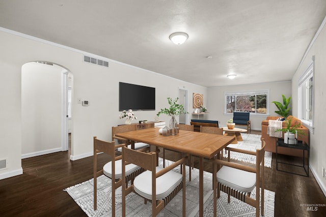 dining room featuring dark hardwood / wood-style flooring and crown molding