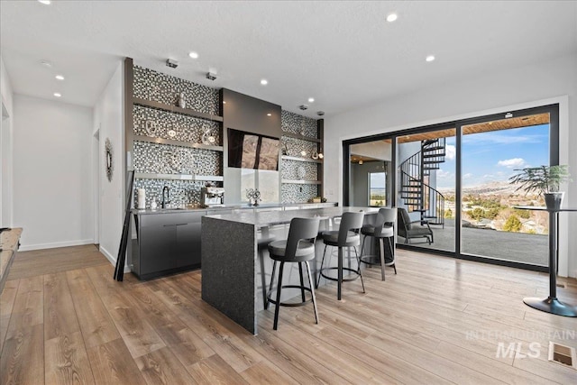 3492 E Heartleaf Dr, Boise, ID 83716 - kitchen featuring open shelves, a kitchen bar, modern cabinets, light wood-type flooring, and a center island