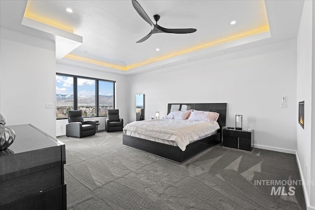 3492 E Heartleaf Dr, Boise, ID 83716 - bedroom featuring a tray ceiling, baseboards, ceiling fan, and carpet flooring
