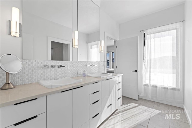 3492 E Heartleaf Dr, Boise, ID 83716 - bathroom featuring double vanity, tile patterned flooring, backsplash, and a sink
