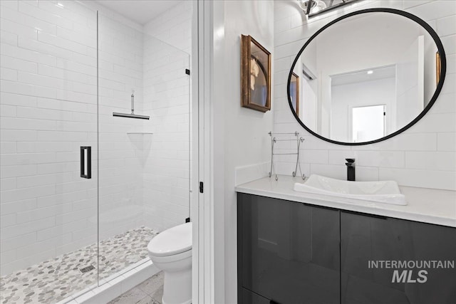 3492 E Heartleaf Dr, Boise, ID 83716 - full bathroom with vanity, a shower stall, toilet, and tasteful backsplash