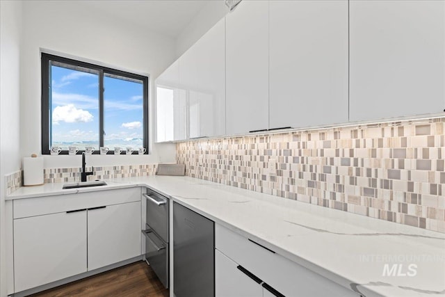 3492 E Heartleaf Dr, Boise, ID 83716 - kitchen with tasteful backsplash, light stone countertops, dark wood finished floors, white cabinetry, and a sink