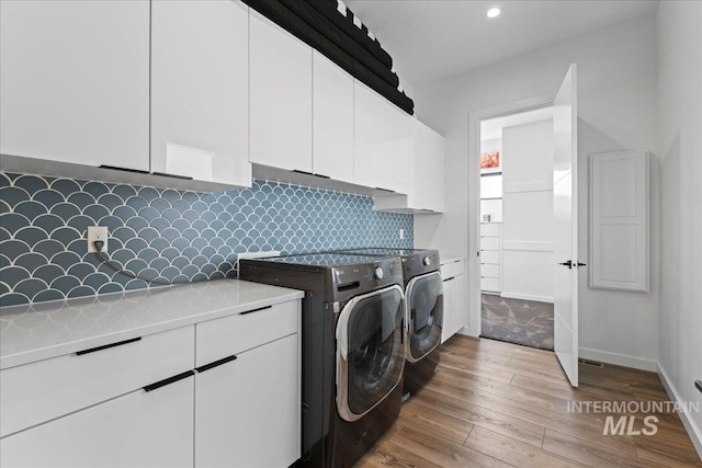 3492 E Heartleaf Dr, Boise, ID 83716 - clothes washing area with wood finished floors, baseboards, recessed lighting, separate washer and dryer, and cabinet space