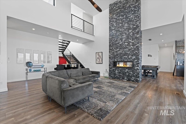 3492 E Heartleaf Dr, Boise, ID 83716 - living area with wood finished floors, a high ceiling, baseboards, stairs, and a tile fireplace