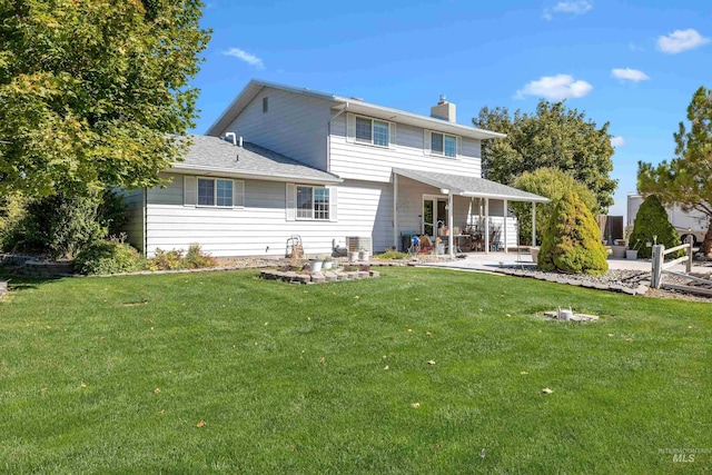 rear view of house featuring a yard and a patio area