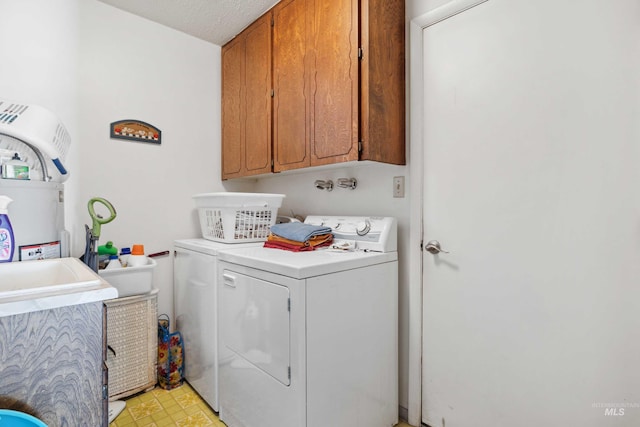 washroom featuring separate washer and dryer, cabinets, and a textured ceiling