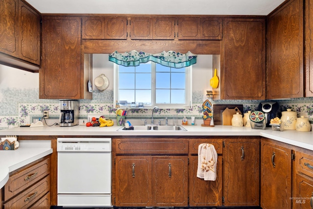 kitchen featuring white dishwasher, backsplash, and sink