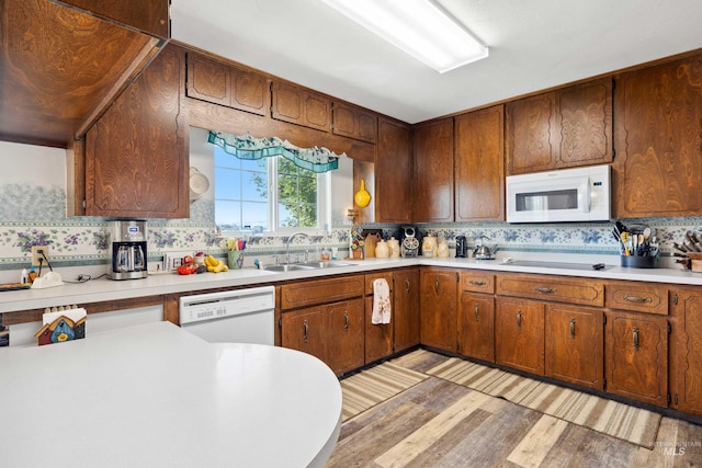 kitchen with light hardwood / wood-style flooring, sink, white appliances, and decorative backsplash