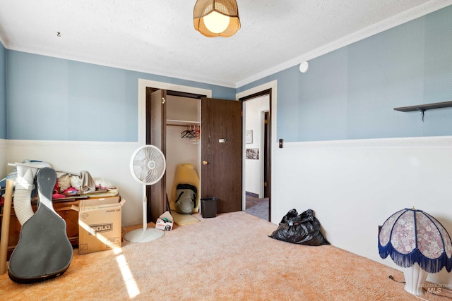 bedroom featuring carpet floors, a textured ceiling, ornamental molding, and a closet