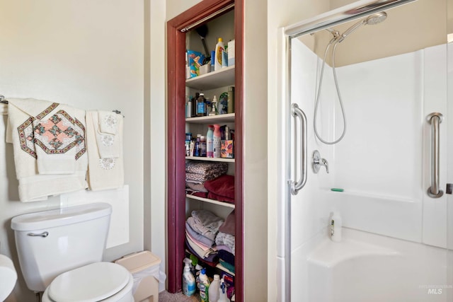 bathroom featuring walk in shower and toilet