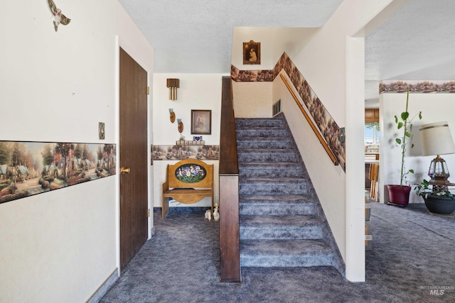 staircase featuring a textured ceiling and carpet floors