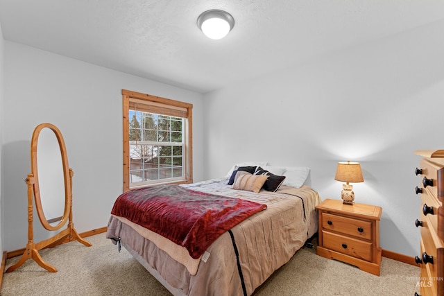 bedroom featuring light colored carpet and a textured ceiling