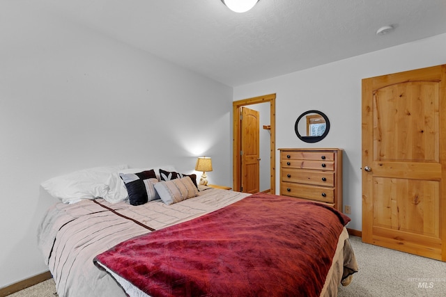 bedroom with light carpet and a textured ceiling