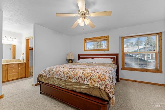 bedroom with a textured ceiling, ceiling fan, ensuite bathroom, and light carpet