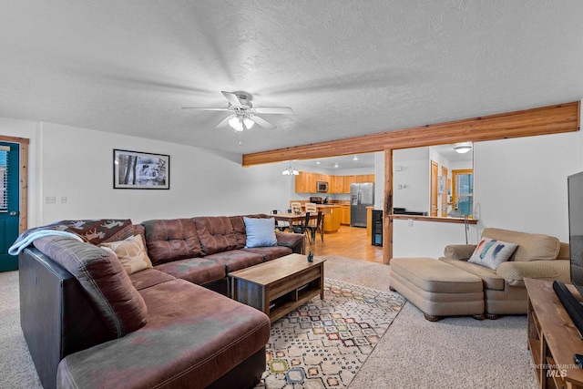 carpeted living room featuring a textured ceiling and ceiling fan