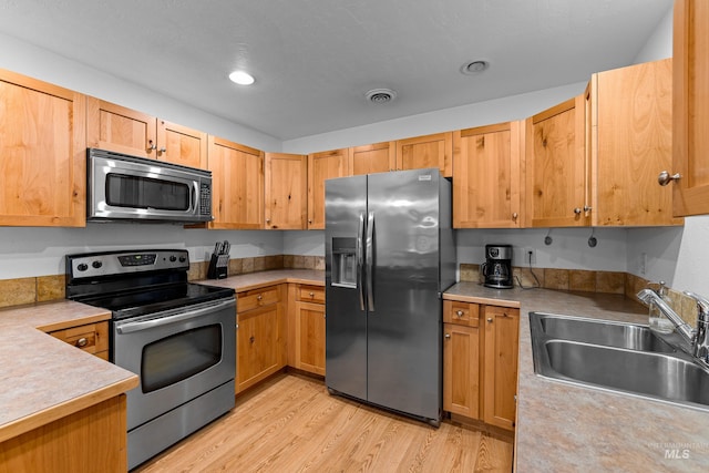 kitchen featuring sink, light hardwood / wood-style flooring, and appliances with stainless steel finishes