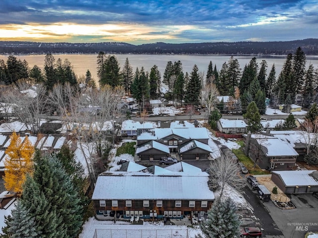 aerial view at dusk featuring a water view