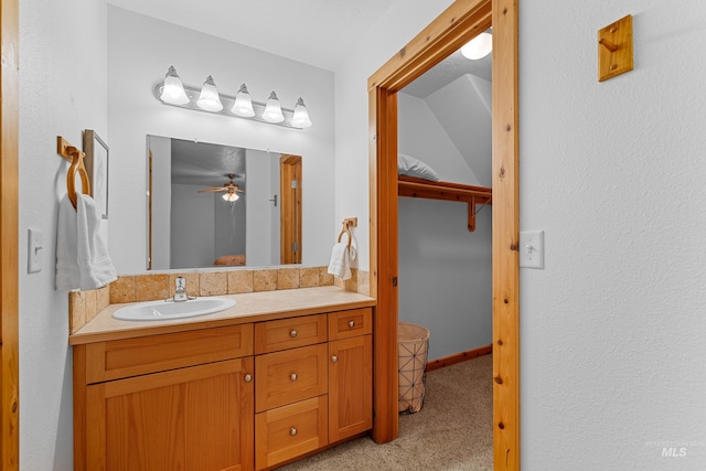 bathroom featuring ceiling fan, vanity, and vaulted ceiling