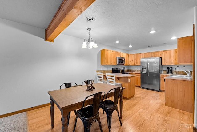 dining space featuring beamed ceiling, light wood-type flooring, sink, and an inviting chandelier