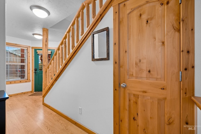 stairway with hardwood / wood-style flooring and a textured ceiling