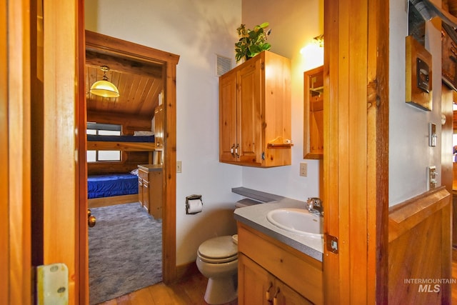 bathroom with toilet, wood ceiling, large vanity, and hardwood / wood-style floors