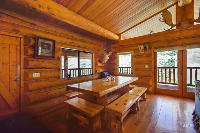 dining room with wood ceiling, dark wood-type flooring, log walls, and lofted ceiling with beams