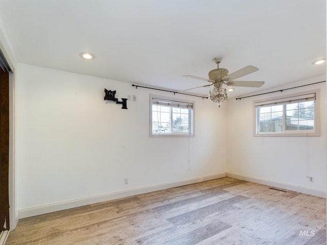 spare room with ceiling fan and light wood-type flooring