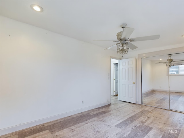 unfurnished bedroom with ceiling fan, a closet, and light hardwood / wood-style flooring