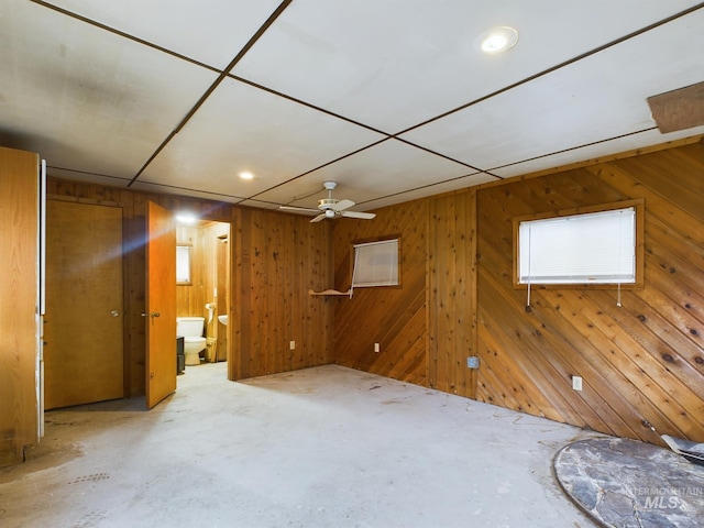 interior space featuring wood walls and ceiling fan