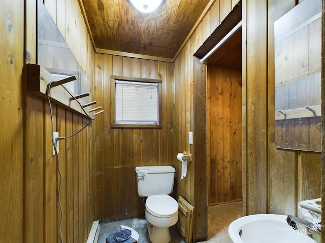 bathroom with baseboard heating, wood walls, wooden ceiling, and toilet