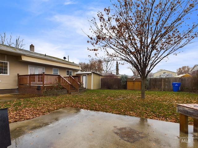 view of yard with a storage shed, a deck, and a patio