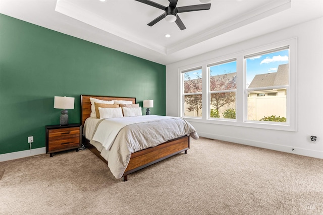 bedroom featuring carpet flooring, a raised ceiling, and ceiling fan