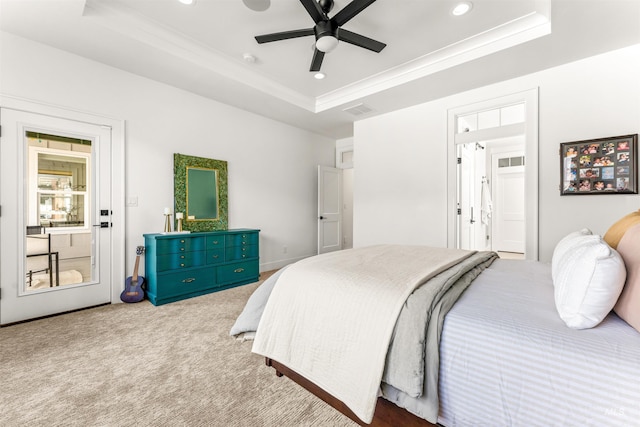 carpeted bedroom with ceiling fan, a raised ceiling, and crown molding