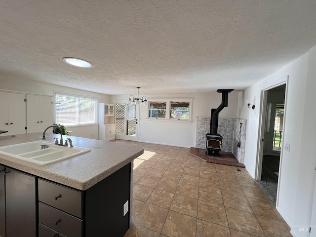 1315 W Howard, Boise, ID 83706 - kitchen featuring a sink, a wood stove, light countertops, a chandelier, and a textured ceiling