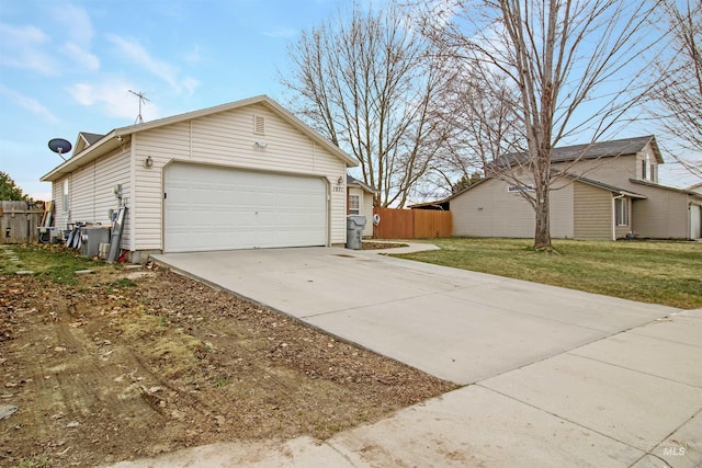 view of side of home featuring fence, a lawn, and driveway