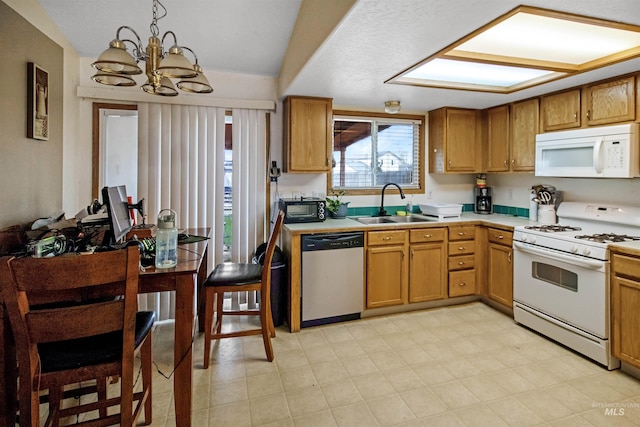 kitchen with white appliances, an inviting chandelier, a sink, vaulted ceiling, and light countertops