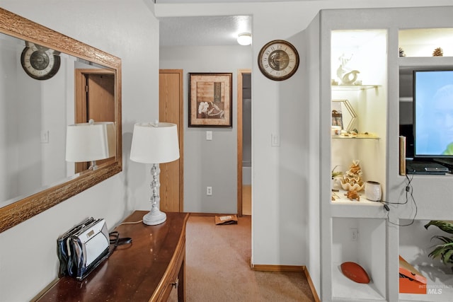 hallway with baseboards and light carpet