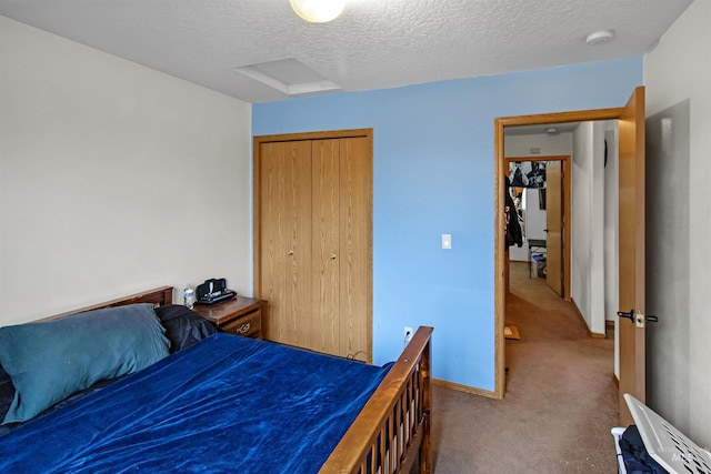 carpeted bedroom featuring baseboards, a closet, and a textured ceiling