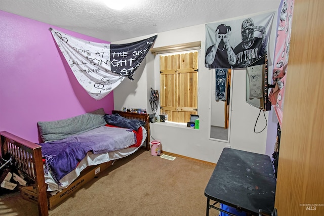 bedroom featuring baseboards, a textured ceiling, and carpet flooring