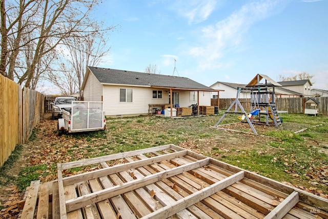 rear view of house featuring crawl space, a playground, and a fenced backyard