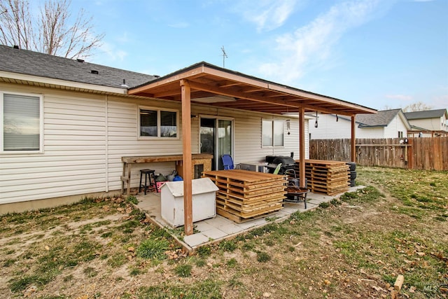 rear view of property with a patio area, a lawn, and fence